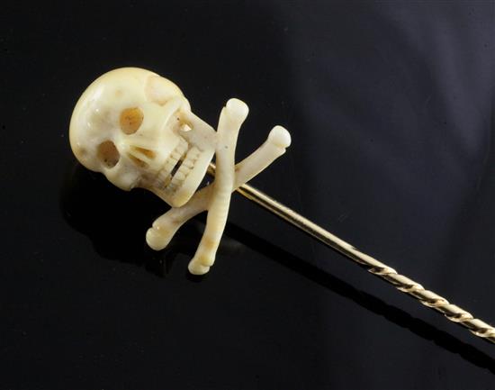 A Victorian gold stick pin with ivory skull and crossbones terminal, 75mm.